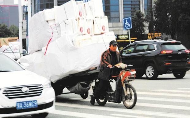武漢一男子車流中拖超高板車“玩雜技” (圖)