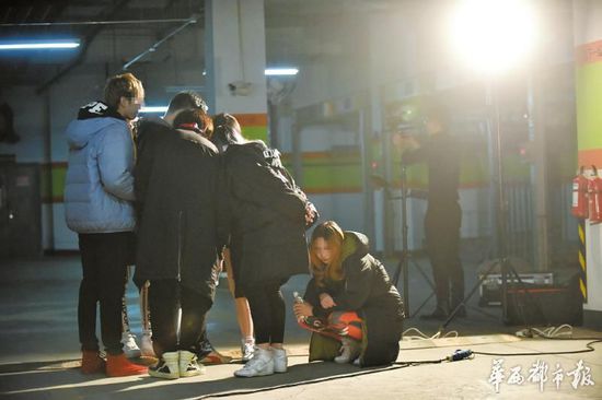 反復排練拍攝,一位女孩累得蹲在地下。