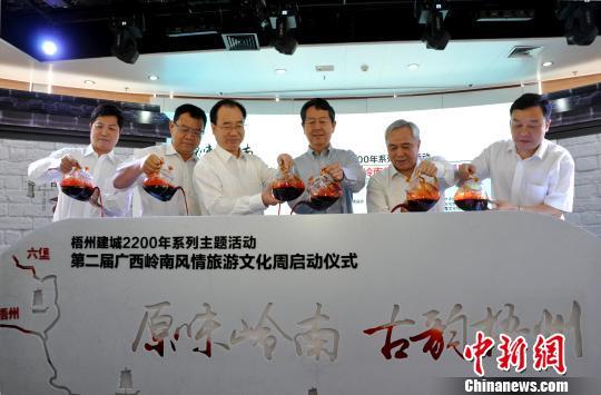 圖為嘉賓將梧州六堡茶注入啟動臺,以茶船古道示意圖來啟動活動周。 黃艷梅 攝